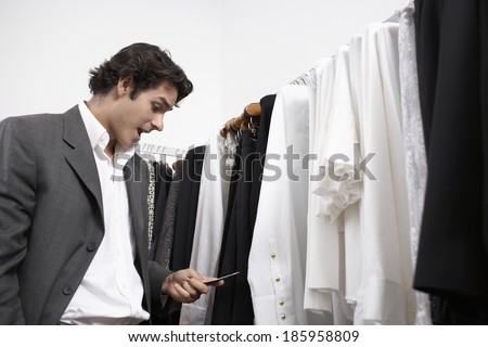 Young man reading price tag in clothing store