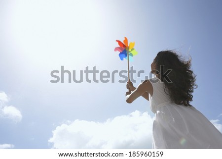 Young woman with pinwheel against sky (low angle view)