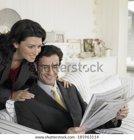 Mid adult couple reading newspaper, South Africa.