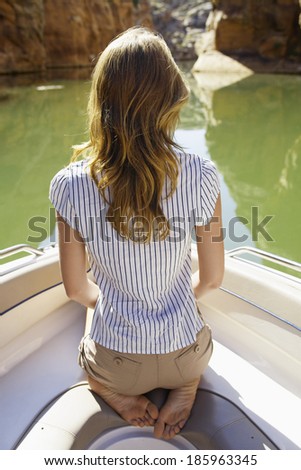Young woman sitting in boat (rear view)
