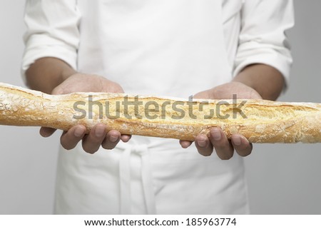 Chef holding baguette (mid section)