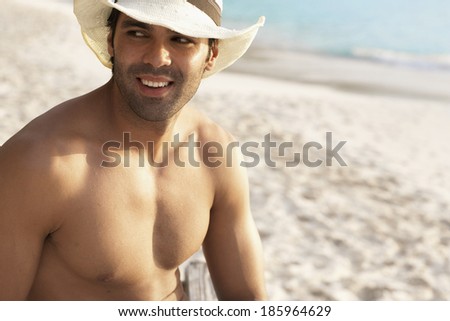 Young man wearing straw hat on beach