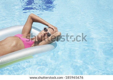 Woman lying on pool raft