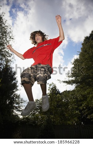 Low angle view of boy (12-13) jumping