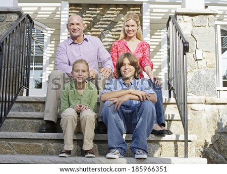 Family of four sitting on steps