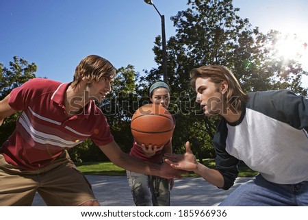 Three People Playing Basketball