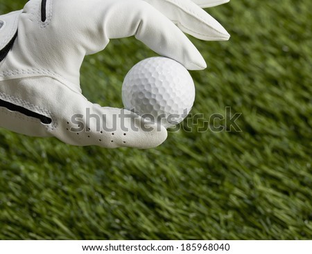 Gloved Human Hand Holding Golf Ball