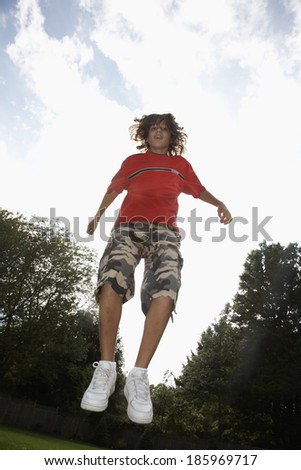 Low angle view of boy (12-13) jumping