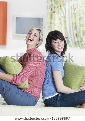 Two Young Women Sitting Back to Back