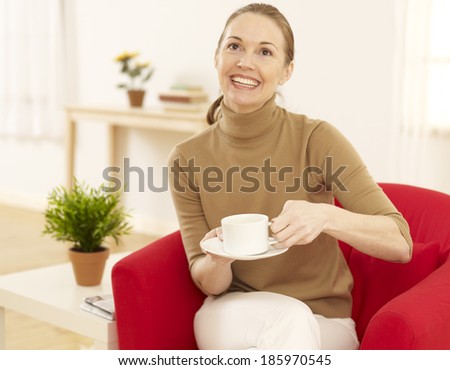 Mid-Adult Woman Drinking Coffee in Living Room