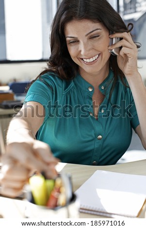 Office Worker on Phone and Reaching for Pen
