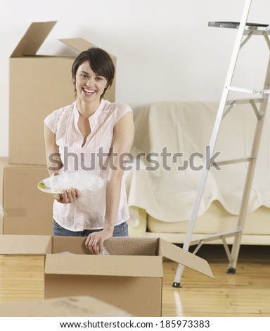 Young Woman Packing Cardboard Boxes