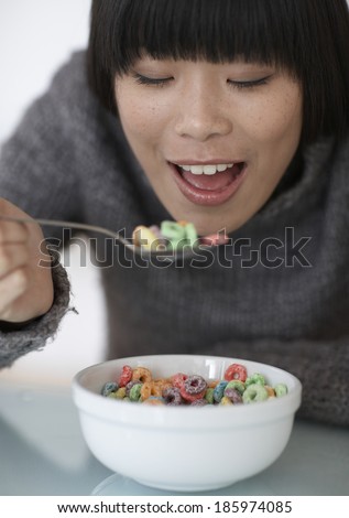 Mid-Adult Woman Eating Colorful Breakfast Cereal