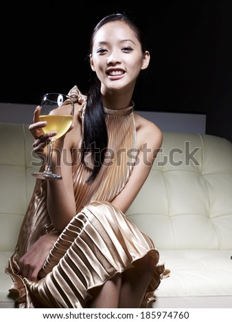 Mid-Adult Woman in Evening Dress Drinking White Wine