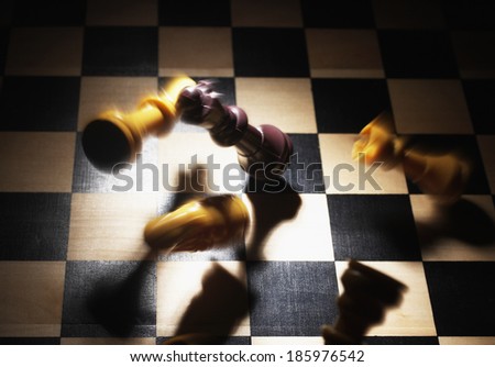 Blurred Chess Pieces Falling on Board