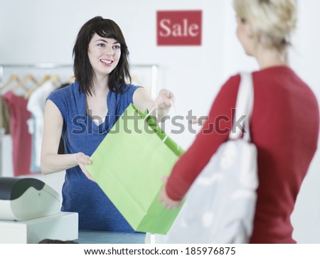 Sales Clerk Giving Shopping Bag to Customer