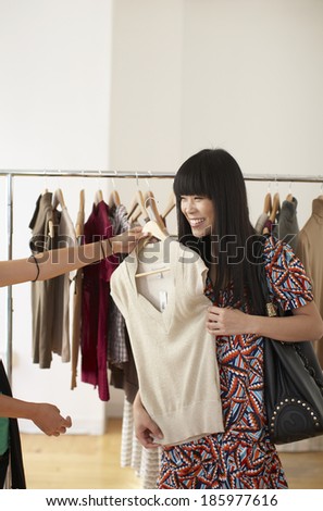Mid Adult Woman Trying on Clothes in Store