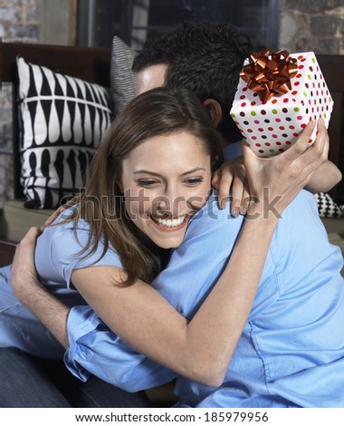 Mid-Adult Woman with Present Hugging Boyfriend