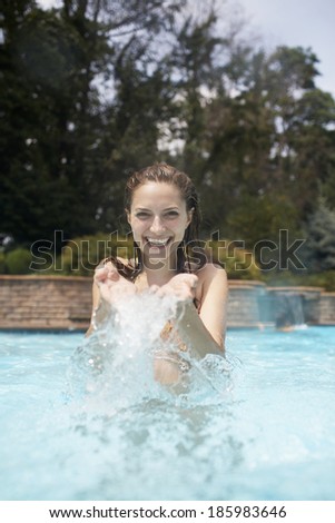 Mid-Adult Woman Splashing Water in Pool