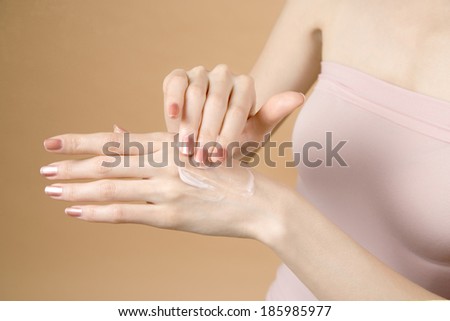 Woman applying lotion to back of hand.