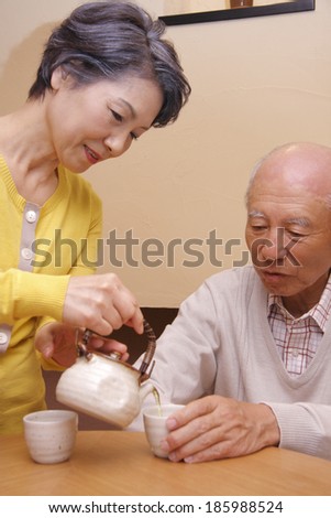 senior woman serving husband tea