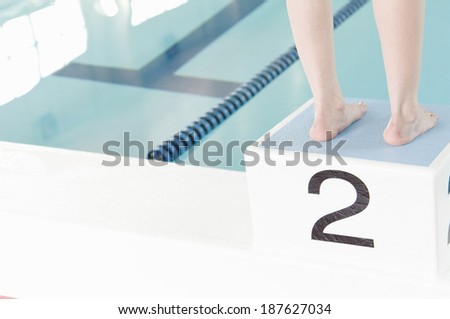 legs of woman standing on diving board