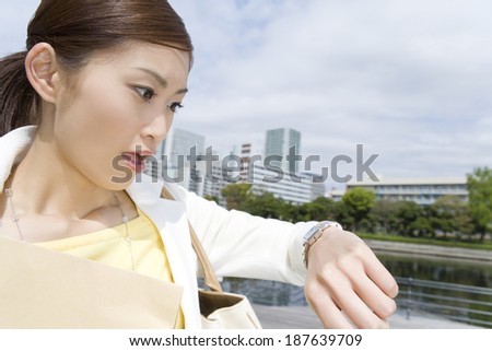 woman looking at watch while running