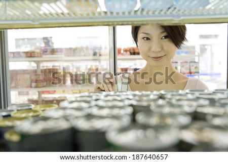 woman choosing drink at convenience store
