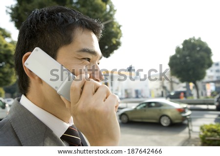 man talking on mobile phone in front of convenience store