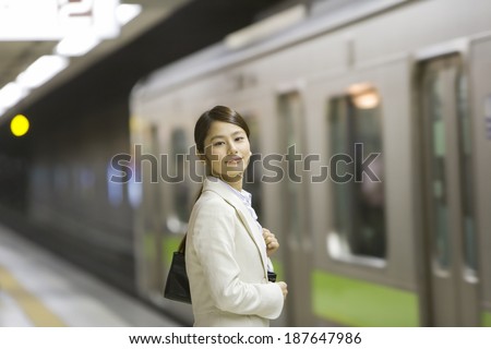 business woman standing on platform and is looking at the camera