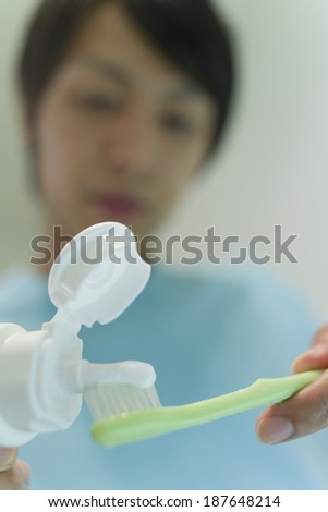 man squeezing toothpaste out of a tube