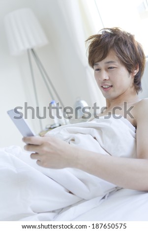 man looks at mobile phone when he just woke up