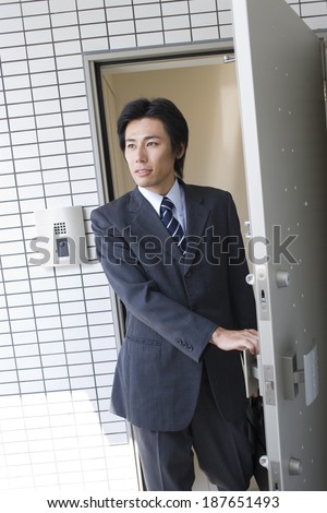 businessman coming out from front door