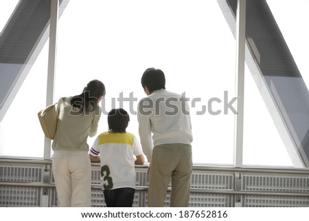 family standing by window and looking outside
