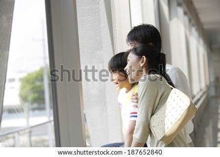 family standing by window and looking outside