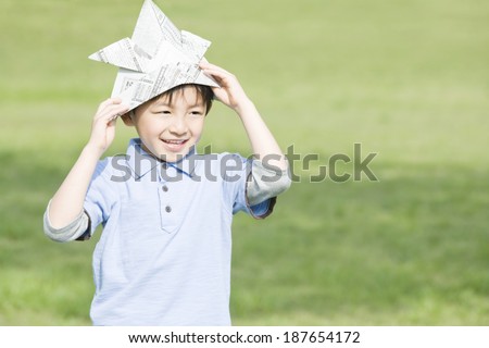 boy wearing samurai warrior helmet made of newspaper