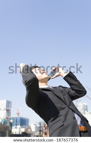man holding up fist with mobile phone