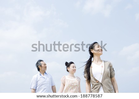 family standing with their back against sky