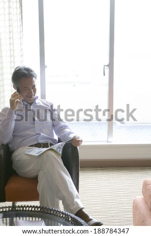 man talking on mobile phone while reading book