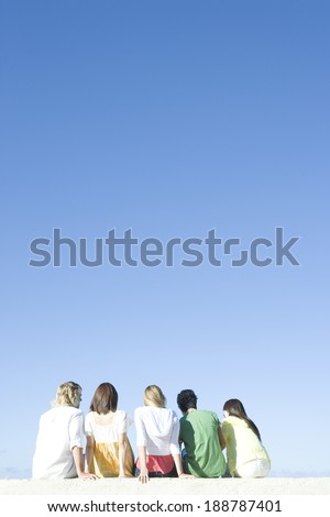 young people sitting on beach and talk
