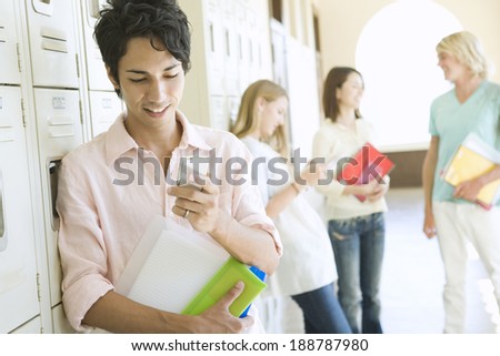 man looking at mobile phone in hallway