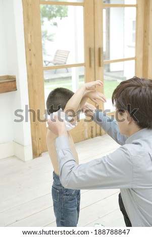 boy having his clothe taken off by father