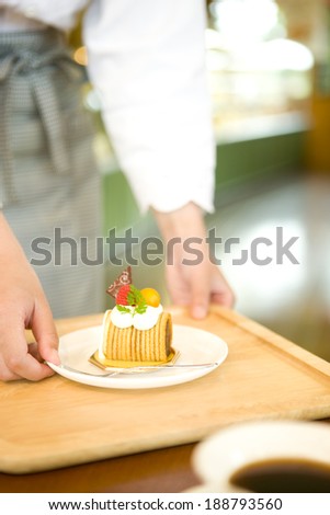 Female staff carring cake to a table