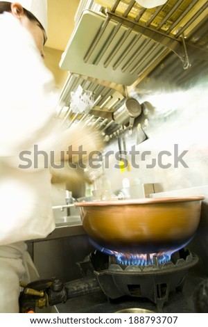 Blurred patissier standing in front of cooking stove