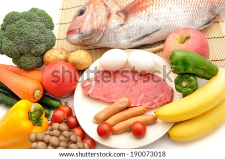 Eggs, bananas, fish, peppers and carrots on a table.
