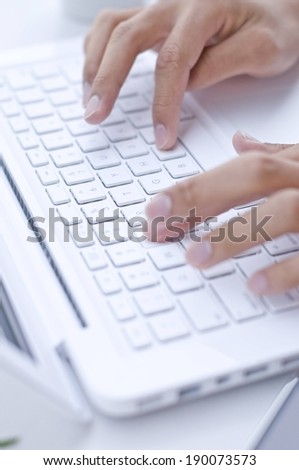 Close-up of a pair of hands typing on a keyboard.