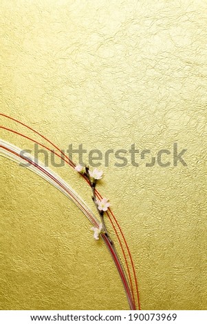 Four flowers laying on curved strings on a gold surface.