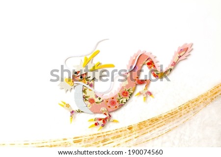 Pink stylized dragon with golden lines below it on a white background.