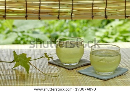 Two lime drinks in glasses on material coasters.