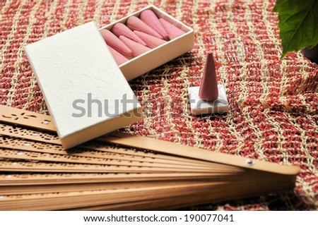 A box of incense cones on a piece of fabric.